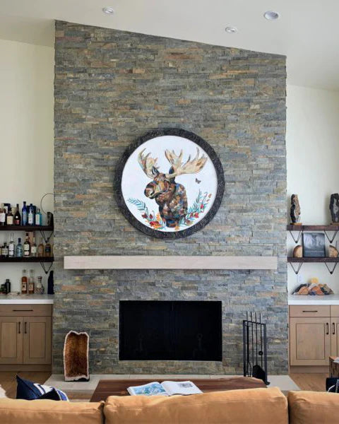 Circular moose collage hanging on a fireplace