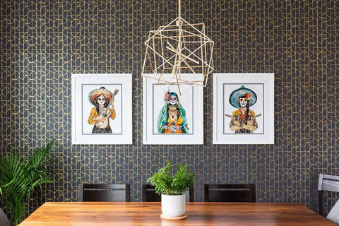 Three art prints in frames of Dia de los Muertos sugar skull women in trendy geometric dining room setting