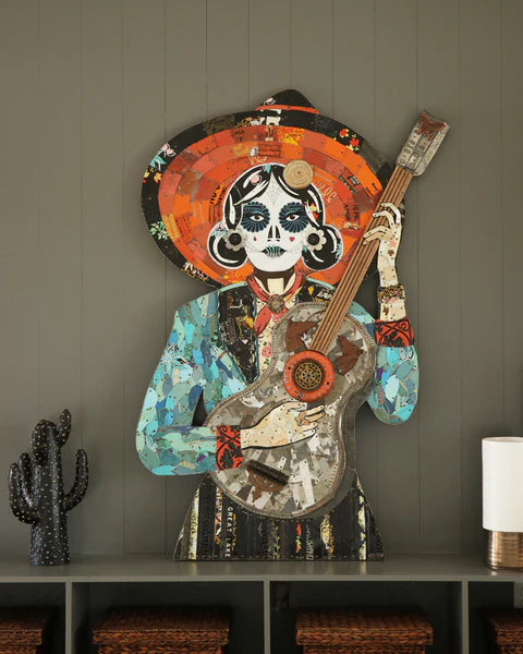 La Guitarrista Metal Assemblage by Dolan Geiman shown propped on low bookcase | a touch of whimsy and tactility for any interior