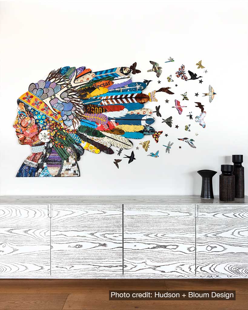 Metal wall sculpture of Native American woman with feathered headdress and flock of birds and insects