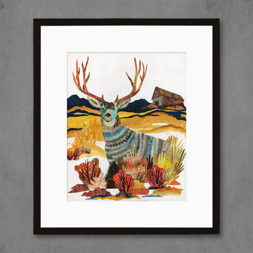 Modern deer art print features a majestic buck standing in a sunshine-filled field with old, wood barn in background